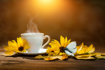 Naklejka na ściany i meble a cup of coffee in the autumn morning, coffee in the morning and sunflower flowers and autumn yellow leaves