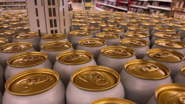 Beer cans on the supermarket shelf. Supermarket windows with yellow beer cans. Supermarket with alcoholic beverages.