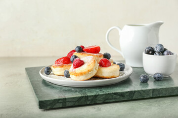 Plate with tasty cottage cheese pancakes and berries on table