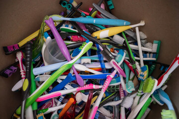 A close-up of many used plastic toothbrushes collected for recycling.