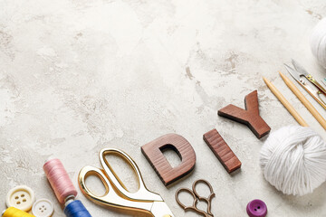 Composition with word DIY and sewing supplies on light background