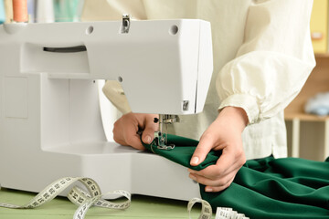 Young woman sewing clothes in studio