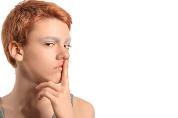 Teenage boy with dyed eyebrows showing silence gesture on white background