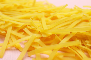 Uncooked fettuccine pasta on color background