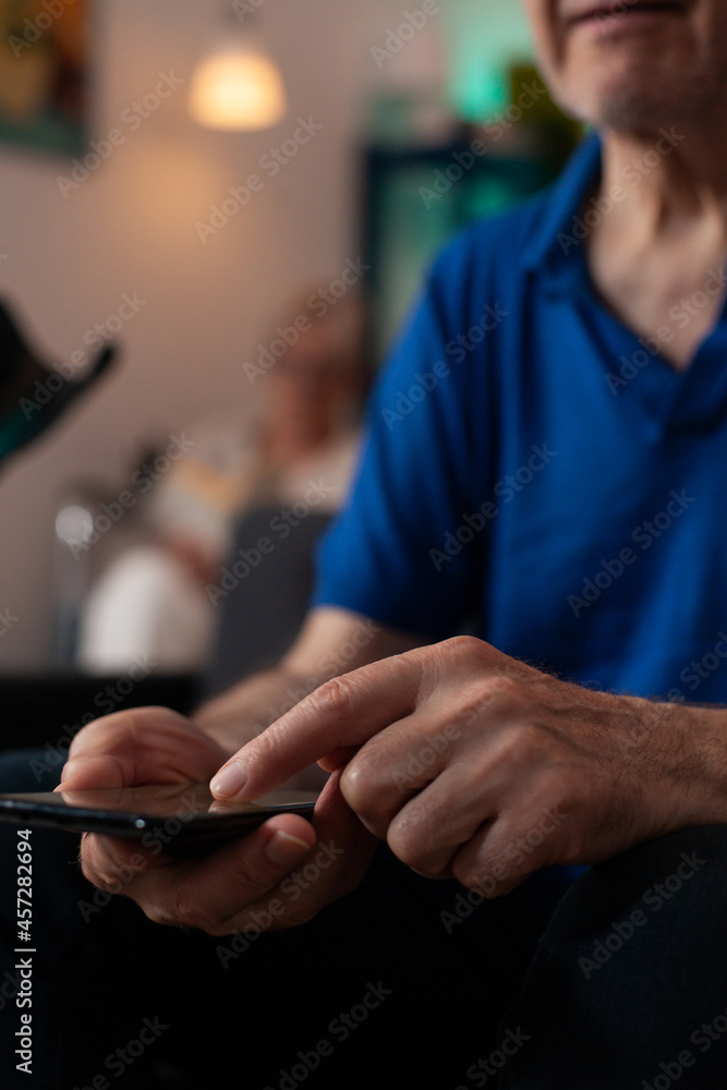 Poster close up of old mature man hand typing on smartphone screen display using modern technology with onl