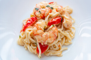Noodles with prawns in cream sauce with cherry tomatoes