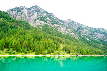 Fototapeta na wymiar Heiterwanger See in Austria. View of the blue-green lake and the surrounding mountains. Landscape near Heiterwang.