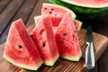 Sliced watermelon on brown wooden background. Close-up, selective focus