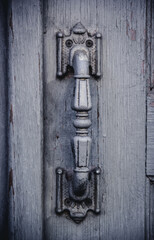 Old iron doorknob on a gray door. Wooden door and doorknob