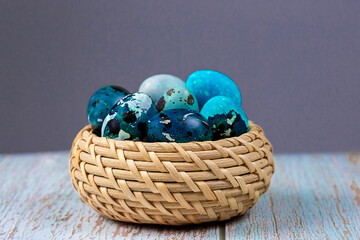 Easter blue quail eggs in a wicker basket