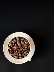 coffee beans in a cup on the black background with copy space