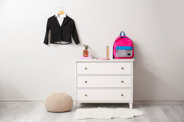 Interior of room with chest of drawers and school uniform