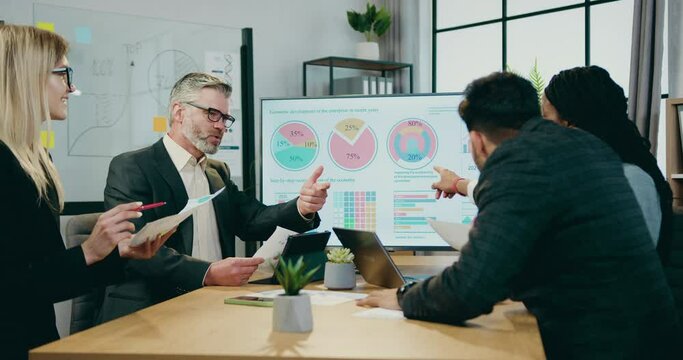 Workflow in company where attractive confident qualified multiracial businesspeople brainstorming together over business strategy of company during meeting