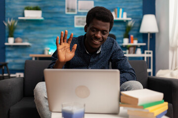 African american man greeting remote collegue during online videocall meeting conference discussing management webinar using school platform on laptop computer. University videoconference telework