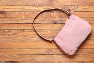 Stylish female handbag on wooden background