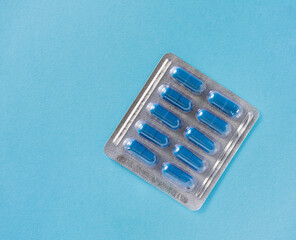 blister with pills, capsules of blue color on a blue background
