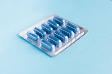 blister with pills, capsules of blue color on a blue background