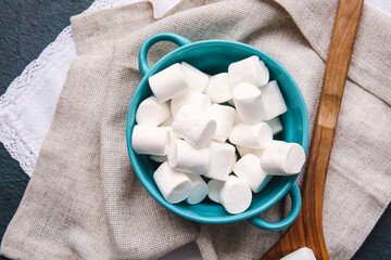 Pot with tasty marshmallows on dark background