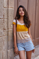 Serene woman casually leaning against a wall