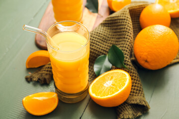 Glass of tasty orange juice on color wooden background, closeup