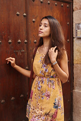 Fototapeta premium Eager lady in waiting while leaning on a door
