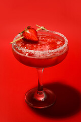 Glass of tasty strawberry margarita on color background