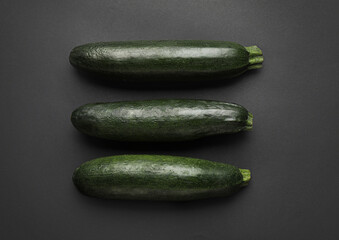 Fresh zucchini squashes on dark background