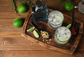 Glasses of cold gin and tonic on wooden background - obrazy, fototapety, plakaty