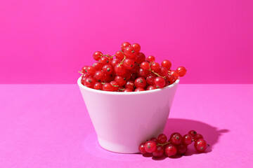 Bowl with fresh red currants on color background, closeup