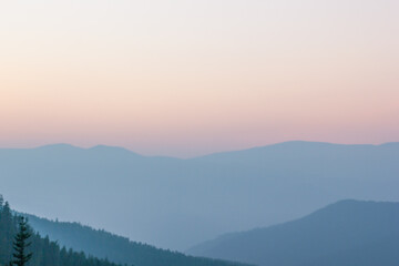 Obraz premium Blurred background smoky mountain landscape with mountain silhouette at sunset.