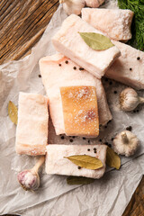 Parchment with pieces of salted lard on wooden background