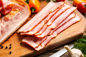 Board with tasty smoked bacon on table