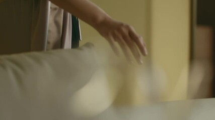 closeup of Asian beauty walking indoors touch couch feather elegantly
