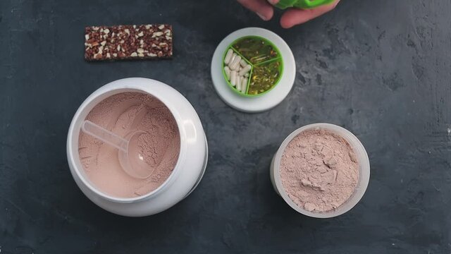 Process of making chocolate powder whey protein drink with milk in a shaker, slow motion, top view