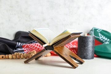 Koran, tasbih, burning candle and flag of Afghanistan on table