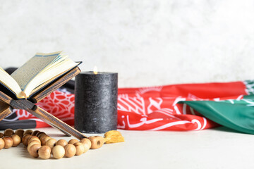 Koran, tasbih, burning candle and flag of Afghanistan on table