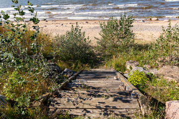 Old wooden stairs leading to seaside of Baltic sea on a sunny day in September in Latvia