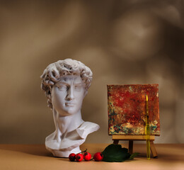 White antique plaster head of David and easel. Art creative concept.