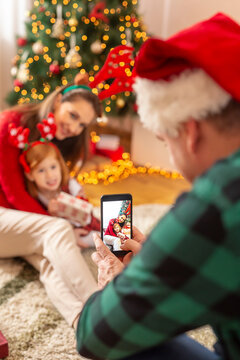 Man taking photos of his wife and daughter on Christmas day