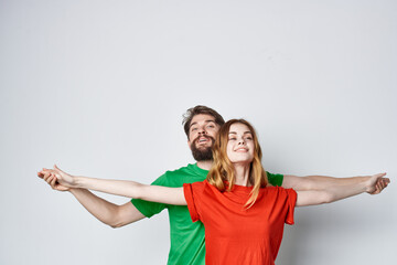 a young couple multicolored t-shirts communication quarrel light background