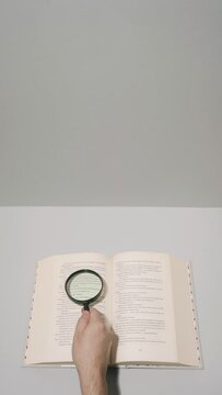 Reading pages of a book with a magnifying glass