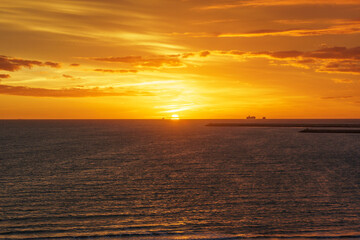 ships sailing on the horizon with sunset