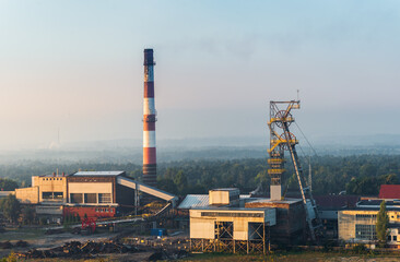 Beautiful view on coal mining 'Boze Dary' in Katowice, Silesia, Poland seen from mining heap at sunrise. Nature versus industry. A mine surrounded by forests. Mining infrastructure. - obrazy, fototapety, plakaty
