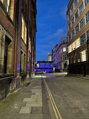 Obraz premium City street at night with buildings and moving traffic. Taken in Manchester England. 