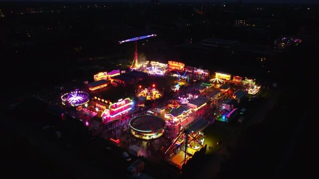 Fair at night with illuminated fairground attractions in various colors in Zwolle during the summer fair.