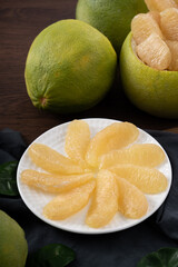 Fresh pomelo fruit on wooden table background.