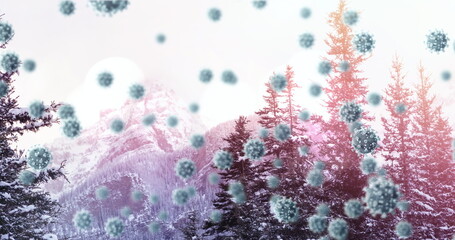 Image of multiple covid 19 cells floating against winter scenery