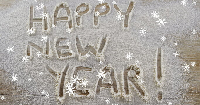 Snowflakes falling against Happy New Year text written in snow