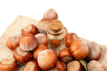 Hazelnut oil in glass bottle isolated on white background. Hazelnut background, healty food