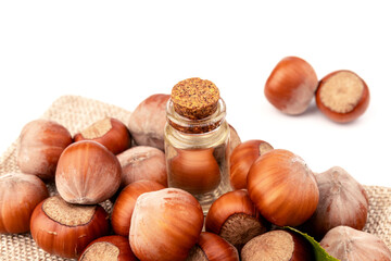 Hazelnut oil in glass bottle isolated on white background. Hazelnut background, healty food